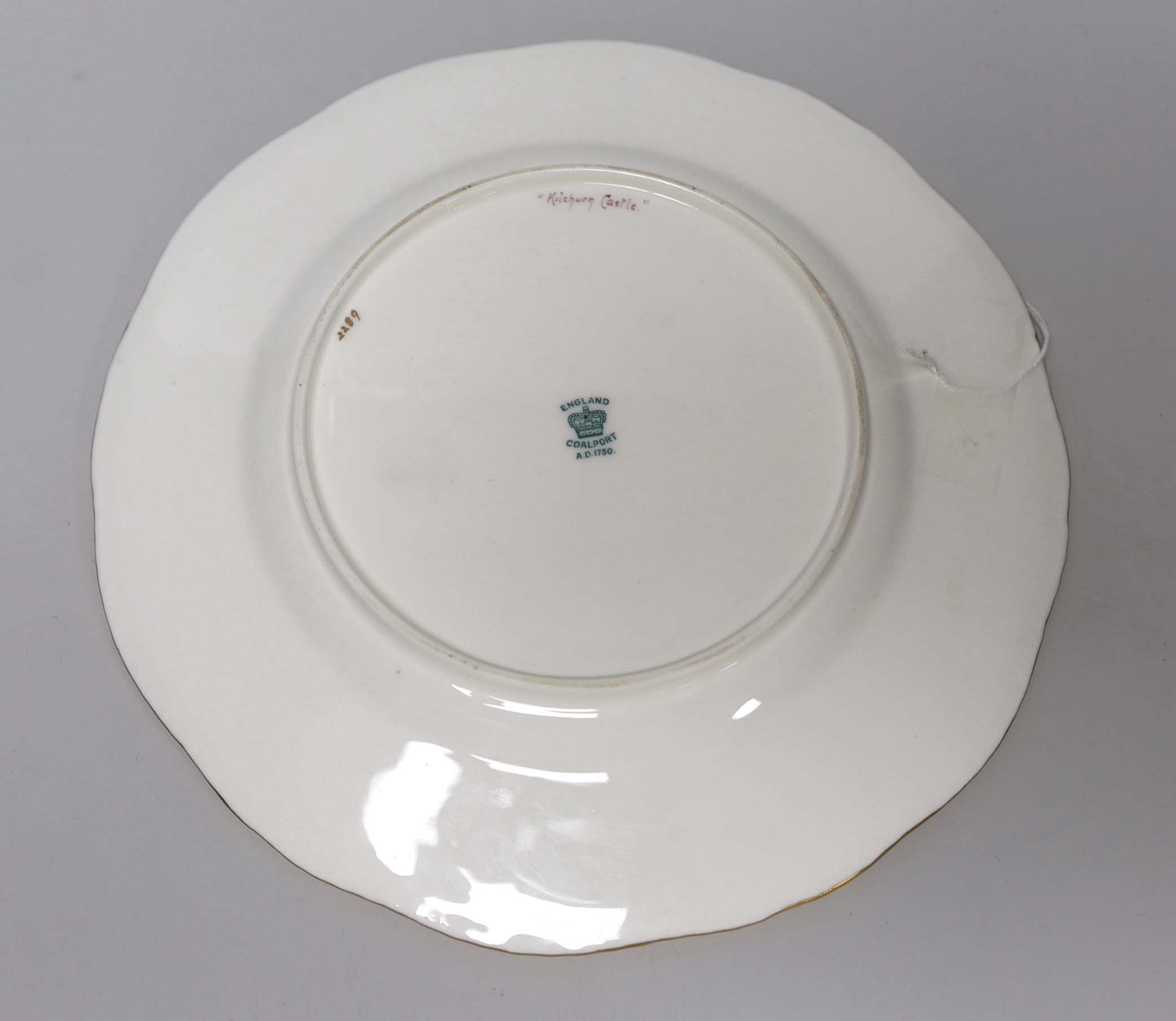 A Coalport gadrooned plate, painted with a view onto Kilchurn Castle by P. Simpson, signed, 23cm in diameter